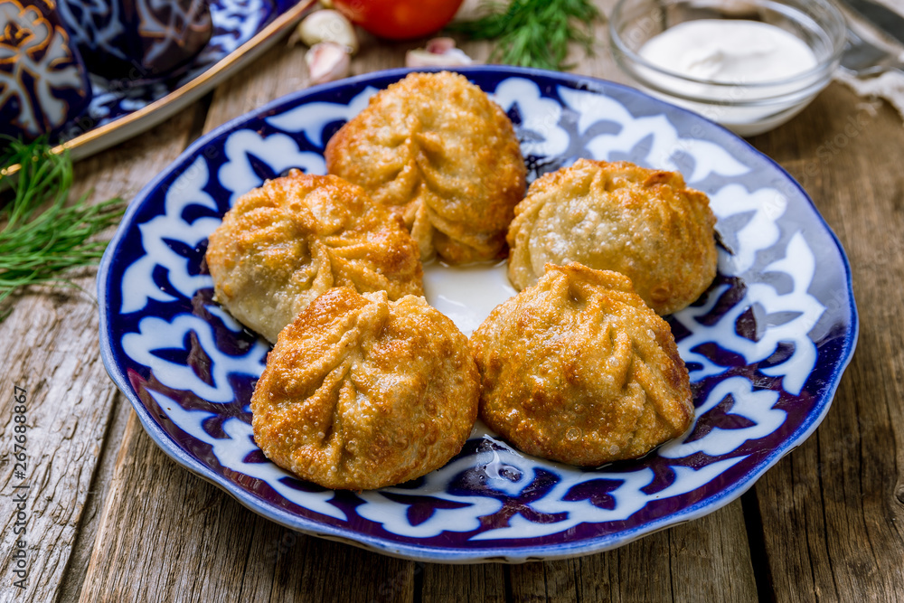 fried manty uzbek cuisine on wooden background