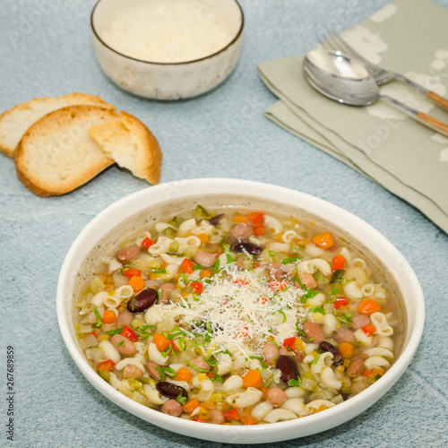 Minestrone soup. Vegetables soup served with parmesan and croutons, rustic background. 