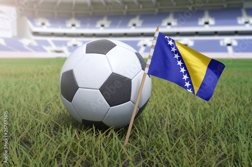 Bosnia and Herzegovina flag in stadium field with soccer football