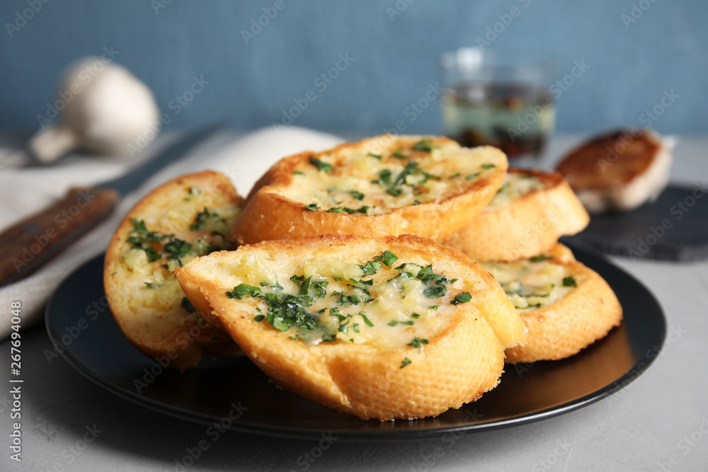 Plate with delicious homemade garlic bread on table Plate with delicious homemade garlic bread on table