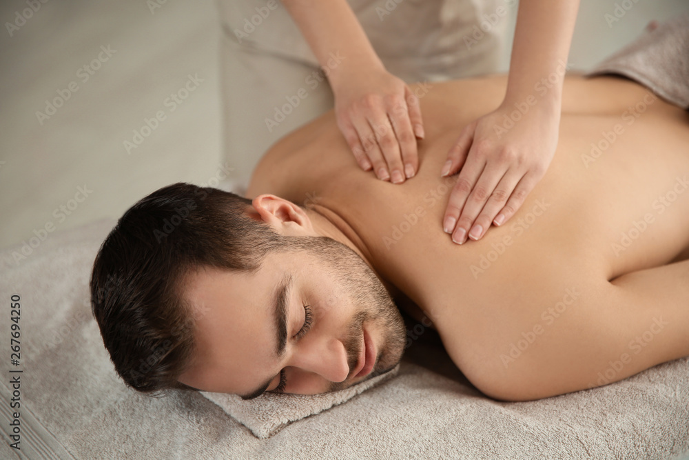 Handsome man receiving back massage in spa salon Handsome man receiving back massage in spa salon