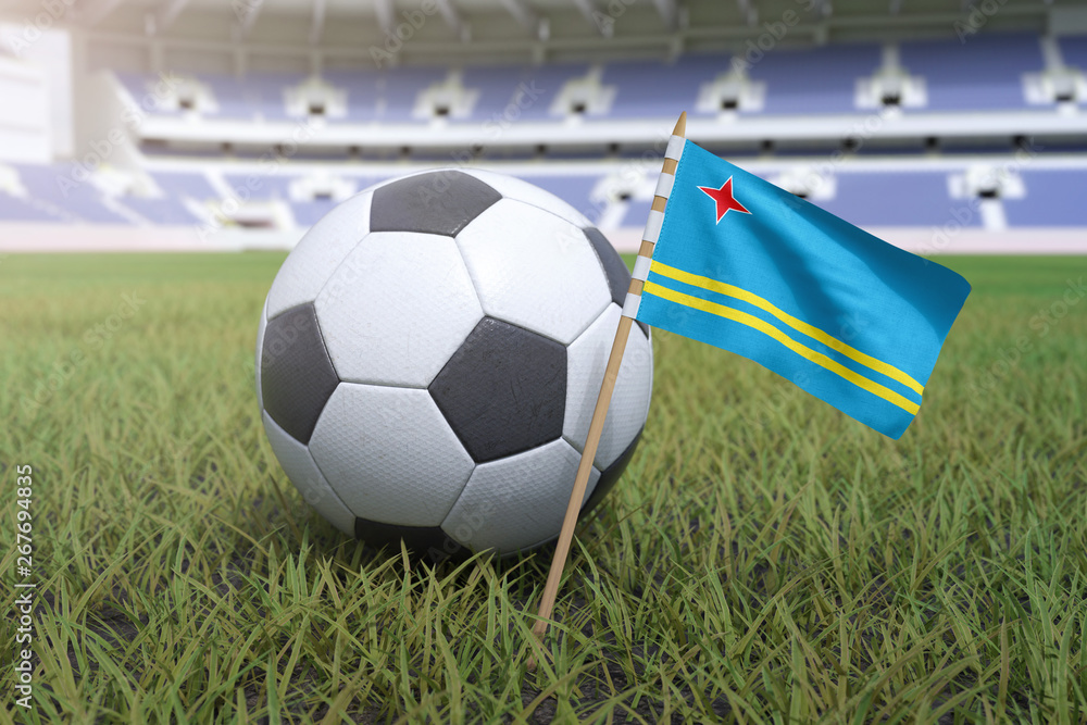 Naklejka premium Aruban flag in stadium field with soccer football