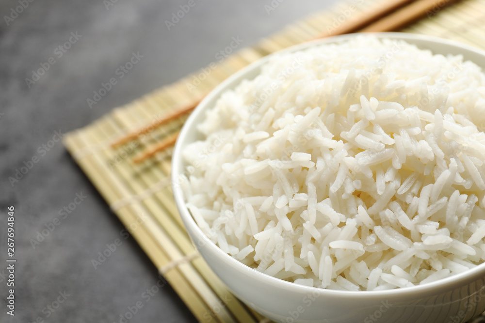 Bowl of tasty cooked rice served on table, closeup. Space for text Bowl of tasty cooked rice served on table, closeup. Space for text