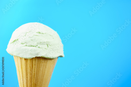 Ice-cream scoop in waffle ice cream cone with copy space. Summer background, vacation, refreshment, traditional seasonal cold sweets