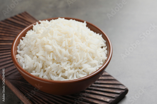 Bowl of tasty cooked white rice on grey table