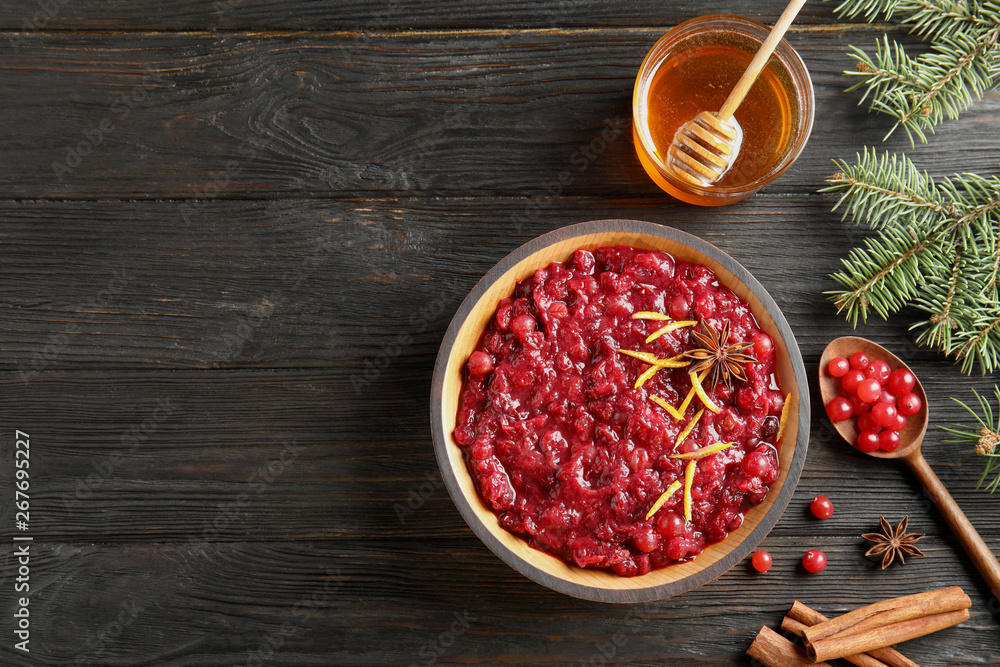 Flat lay composition with cranberry sauce in plate on wooden background. Space for text Flat lay composition with cranberry sauce in plate on wooden background. Space for text