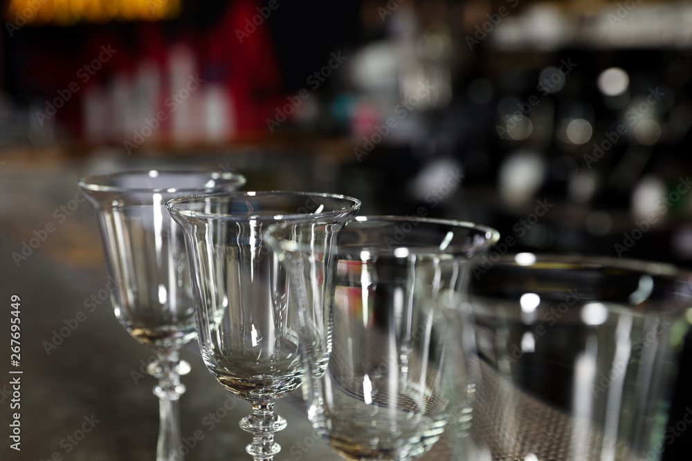 Row of empty clean glasses on counter in bar, closeup Row of empty clean glasses on counter in bar, closeup