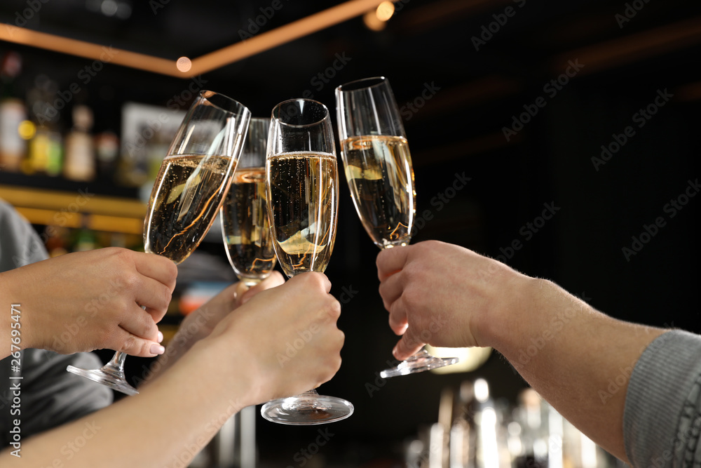Friends clinking with glasses of champagne in bar, closeup Friends clinking with glasses of champagne in bar, closeup