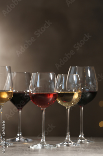 Glasses with different wines on table against dark background. Space for text