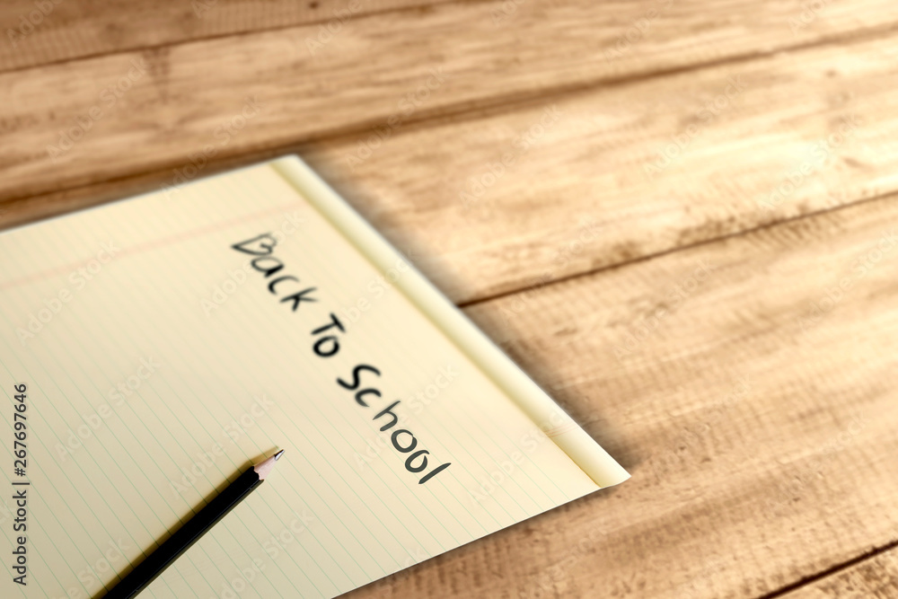 Paper and pencil with Back to School message on wooden table Paper and pencil with Back to School message on wooden table