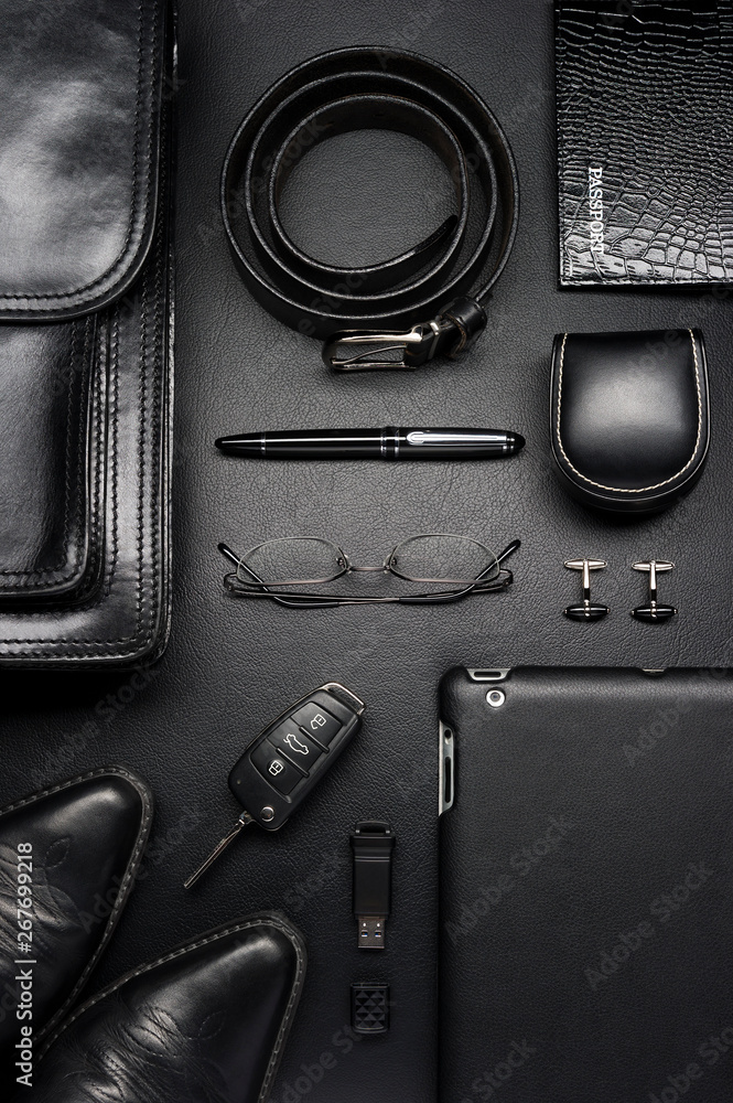 Man accessories in business style, clothes, gadgets, jewelry, sunglasses  and other luxury businessman attributes on leather black background,  fashion industry, selective focus Stock Photo