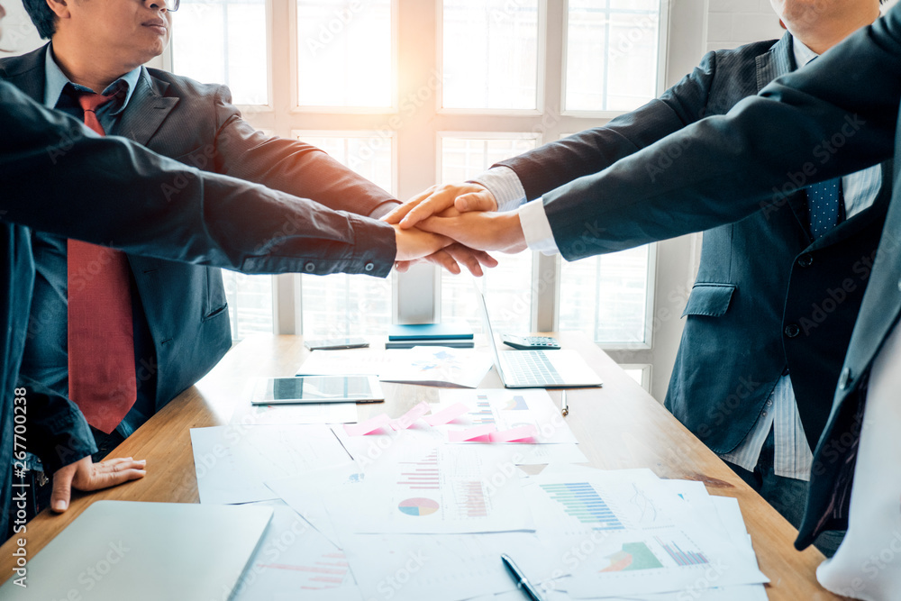 Businesspeople teamwork group putting their hands together agreement plan in meeting room, investment concept, success concept Businesspeople teamwork group putting their hands together agreement plan in meeting room, investment concept, success concept