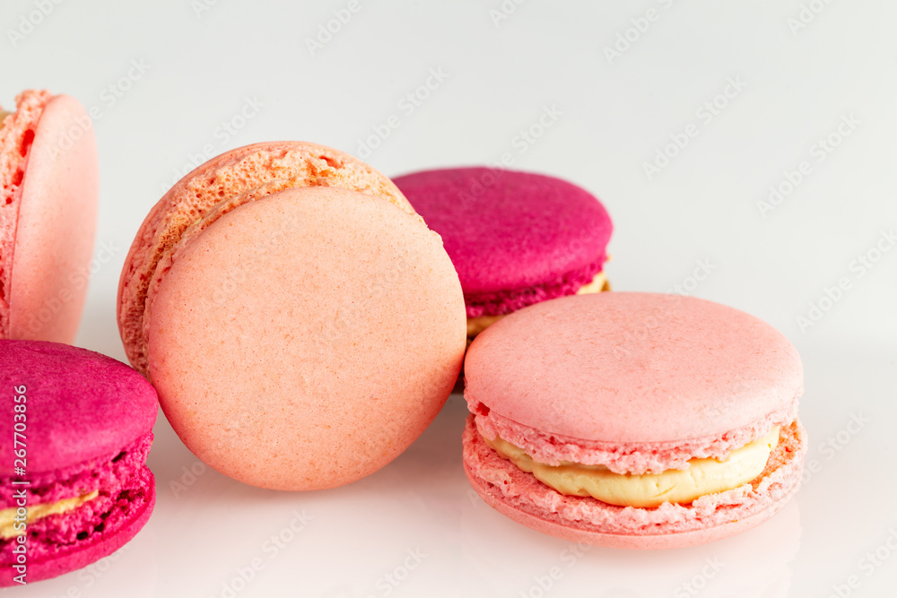 French pink macarons or macaroons closeup, side top view on a white background. French pink macarons or macaroons closeup, side top view on a white background.
