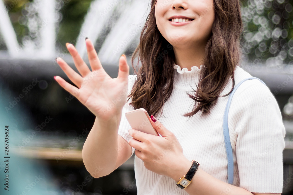 待ち合わせ相手に手を振る女性 Stock Photo Adobe Stock