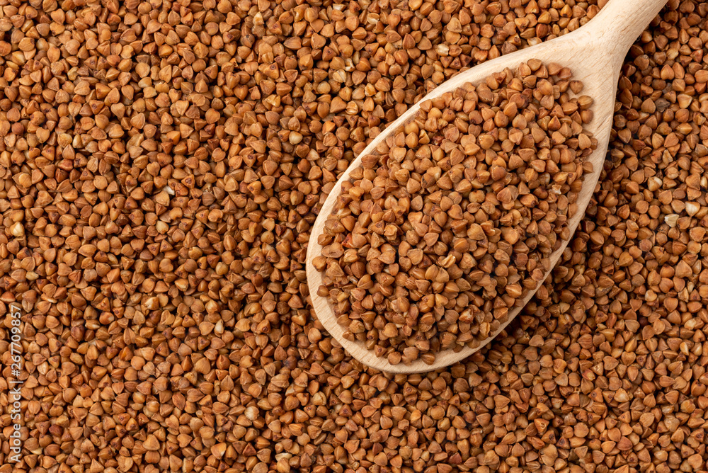 Buckwheat background with wooden spoon. Buckwheat background with wooden spoon.