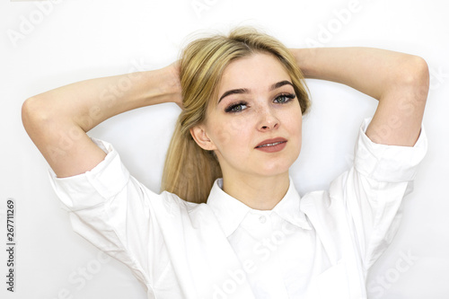 The girl the blonde holds a hand long hair. Bright room, close-up. Personal care.