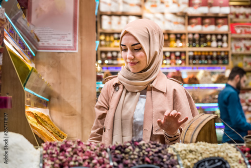 Photography Beautiful muslim woman looks at spices and herbs