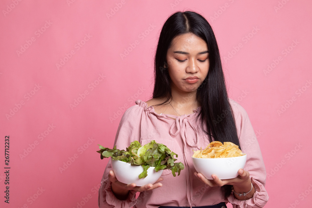 Young Asian woman with potato chips and salad. Young Asian woman with potato chips and salad.
