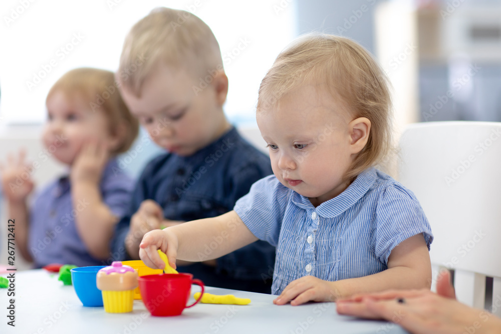 Group of babies kids engaged in handcrafts in nursery Group of babies kids engaged in handcrafts in nursery