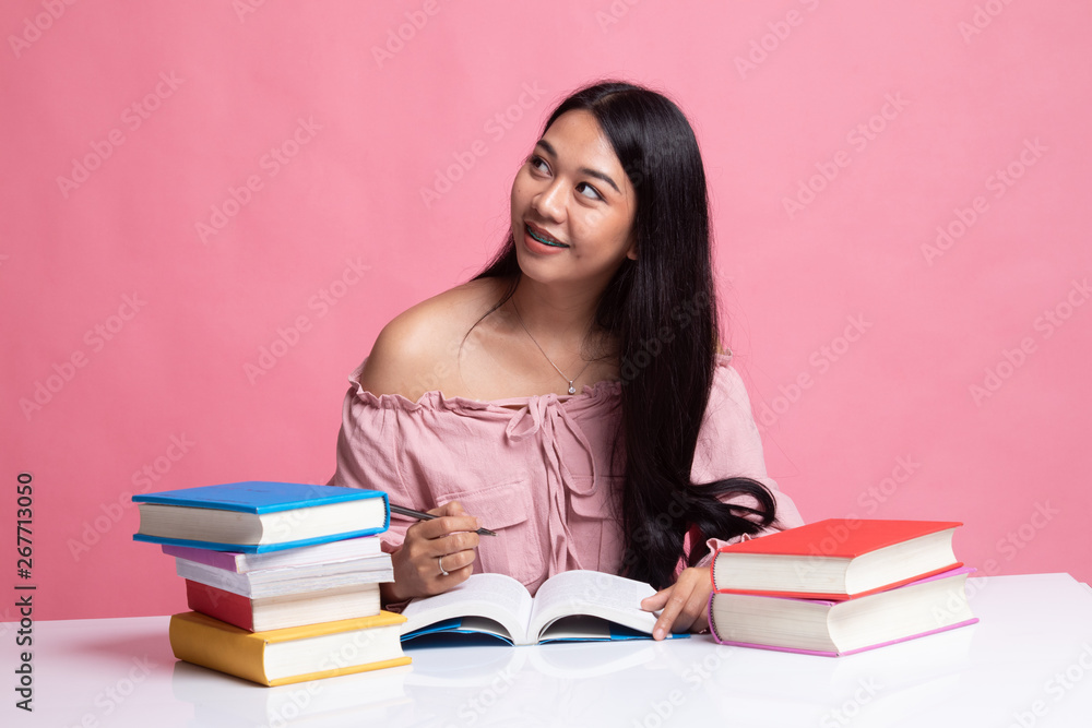 Young Asian woman read a book with books on table. Young Asian woman read a book with books on table.