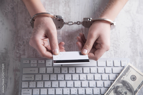 Hands in handcuffs with credit card.