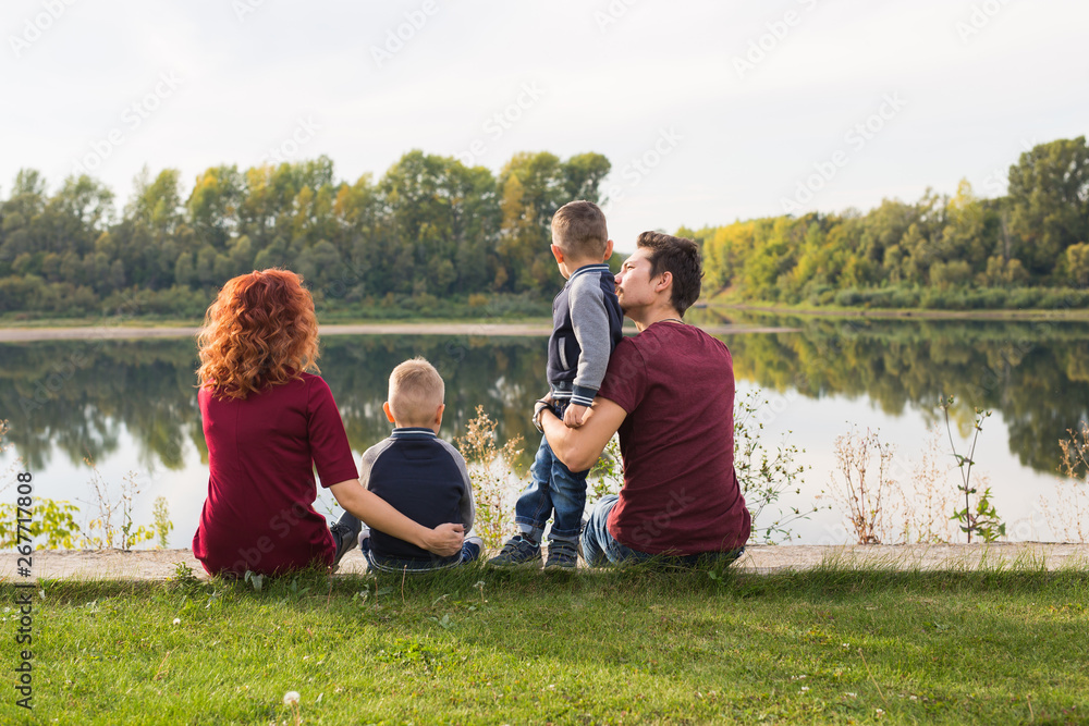 Children, parenthood and nature concept - Big family sitting on the grass Children, parenthood and nature concept - Big family sitting on the grass