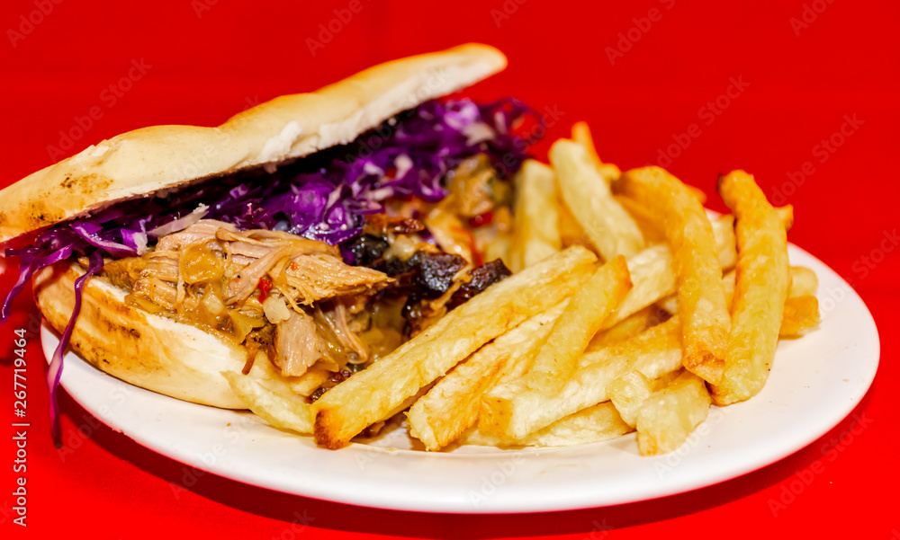Pork cabbage sandwiches and fries. Plated with a red background. Pork cabbage sandwiches and fries. Plated with a red background.