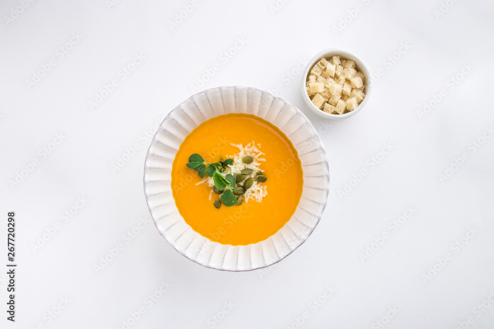 Pumpkin soup with cream and pumpkin seeds and croutons isolated on white background Pumpkin soup with cream and pumpkin seeds and croutons isolated on white background