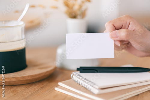 A hand holding and showing white empty business card