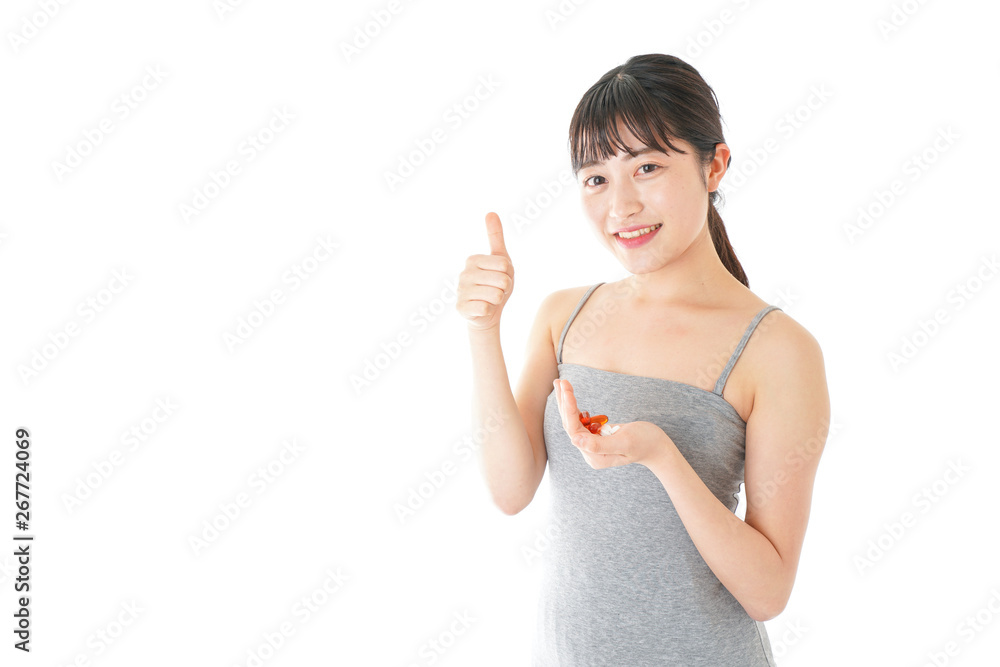 薬・サプリメントを服用する若い女性
