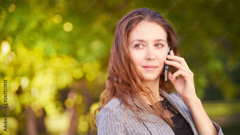 Young happy girl talks cellphone. Phone roaming. People with smartphone. Autumn background Young happy girl talks cellphone. Phone roaming. People with smartphone. Autumn background