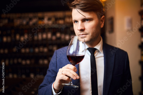 handsome awesome man enjoys drinking wine. close up photo.man has extensive knowledge of wine production and wine service