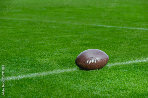 American football  rugby ball on green grass field background