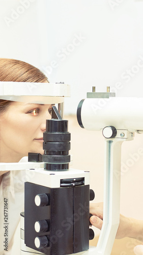 Eye ophthalmologist exam. Eyesight recovery. Astigmatism check concept. Ophthalmology diagmostic device. Beauty girl portrait in clinic photo