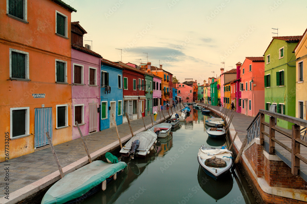 Old colorful houses and boats at sunset in Burano, Venice Italy