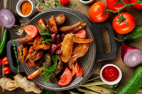Top view board of various meat set of fried chicken, sausages at decorated with vegetables wooden table background.