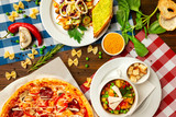 Top view image of italian style business lunch of pizza, soup and salad at wooden table background.