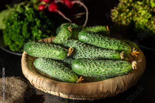 Fresh cucumbers in a basket. Blurred background.