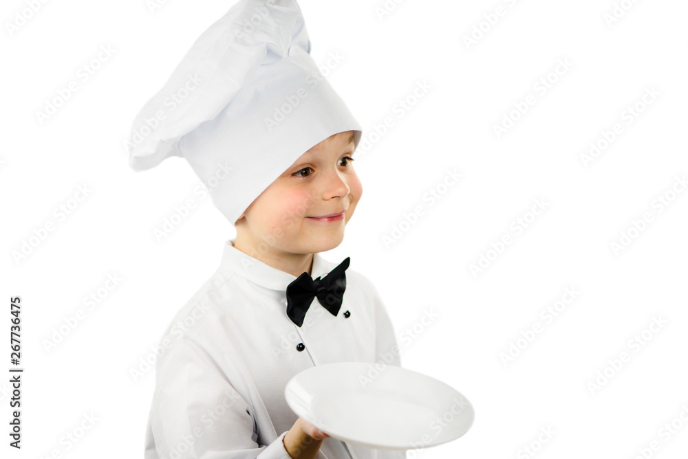 cute funny boy chef in uniform holds a clean empty white plate in his hand