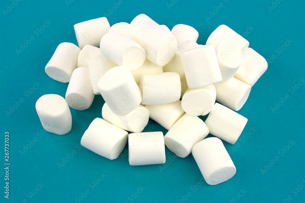 Mini marshmallows on a blue background. geometric pattern of white marshmallows. Mini marshmallows on a blue background. geometric pattern of white marshmallows.