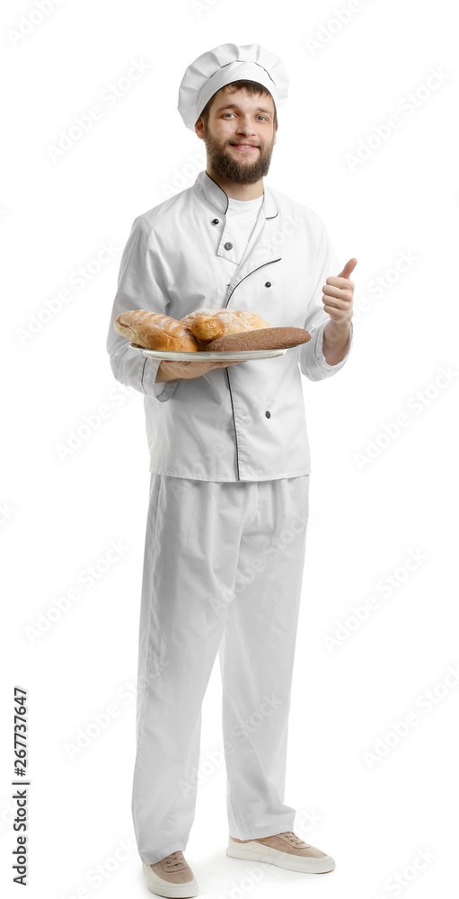 Young chef with fresh bakery products showing thumb-up gesture on white background Young chef with fresh bakery products showing thumb-up gesture on white background