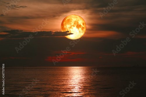 full blood moon on night sky over sea silhouette cloud