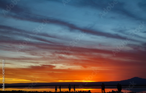 Sunset in salar with orange sky and tourists