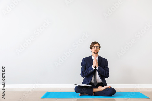 Businessman practicing yoga indoors