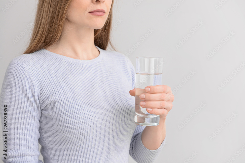 Woman with glass of fresh water on light background Woman with glass of fresh water on light background