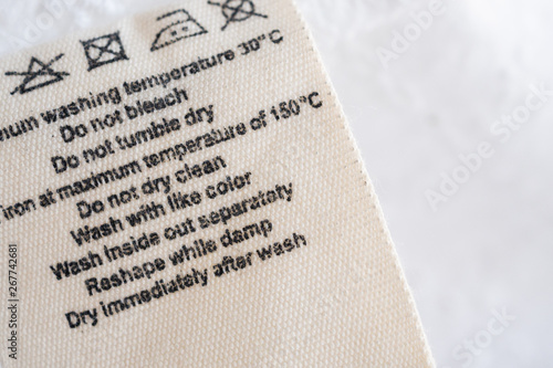 laundry care washing instructions clothes label on fabric texture background
