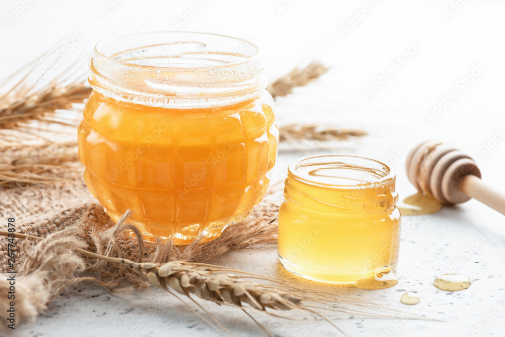Jar of natural honey on white concrete background Jar of natural honey on white concrete background