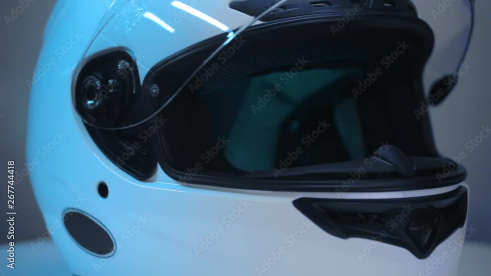 White motorcycle full-face helmet rotates on gray background. White motorcycle full-face helmet rotates on gray background.