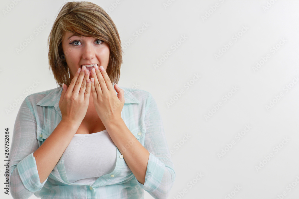 surprised young woman with hands over mouth surprised young woman with hands over mouth