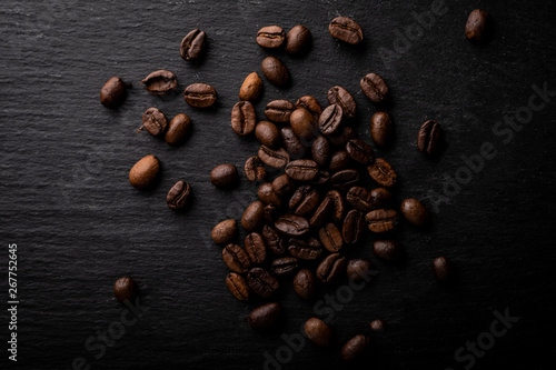 Coffee beans. Roasted coffee fries on a dark table.